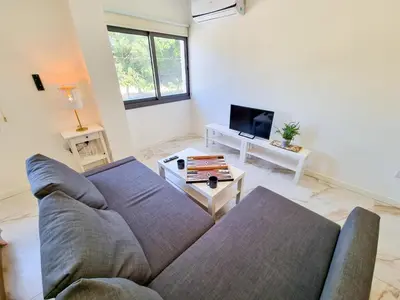 a living room with a couch and a tv at Happy Homes Paradise in Larnaka