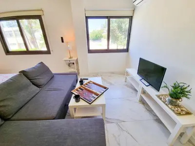 a living room with a couch and a tv at Happy Homes Paradise in Larnaka