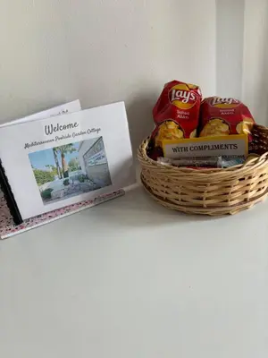 a basket of chips and a book on a shelf at Mediterranean poolside garden cottage in Kiti