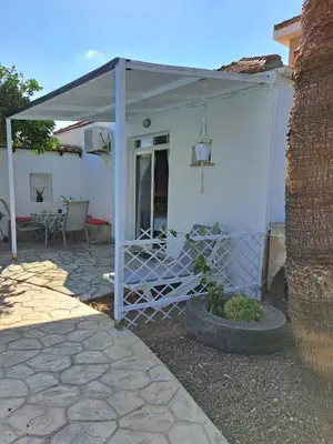 a white pergola on the side of a house at Mediterranean poolside garden cottage in Kiti