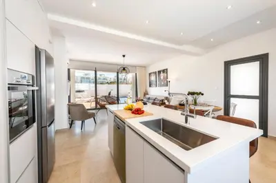 a kitchen with a sink and a living room at Protaras Sol e Mar Villa 1 in Protaras