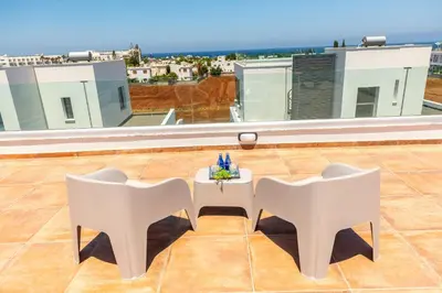 a white table and chairs on a roof at Protaras Sol e Mar Villa 1 in Protaras