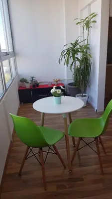 a table and two green chairs in a room at Achillion Apartments By 'Flats Nicosia' in Nicosia
