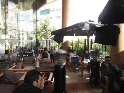 a group of people sitting at tables in a restaurant at Achillion Apartments By 'Flats Nicosia' in Nicosia