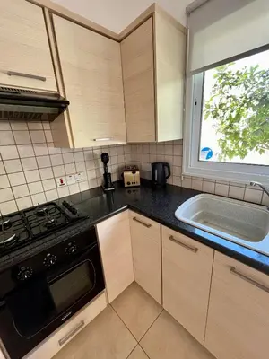 a kitchen with a stove and a sink and a window at Villa Katia in Protaras