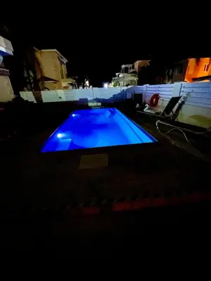 a blue swimming pool lit up at night at Villa Katia in Protaras