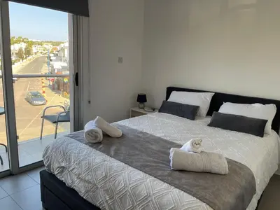 a large bed with a stuffed animal on top of it at Cielo Apartment No2 in Ayia Napa