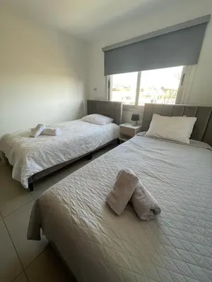 two beds with towels on them in a bedroom at Cielo Apartment No2 in Ayia Napa