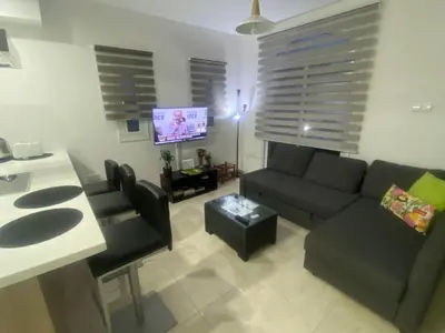 a living room with a couch and a tv at Villa Mario - 2min walk from Kapparis Beach in Paralimni