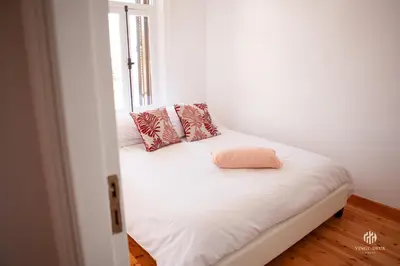 a white bed with a pink pillow on top of it at VINGT-DEUX Vouni 22 in Vouni