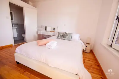 a white bed in a room with a bathroom at VINGT-DEUX Vouni 22 in Vouni