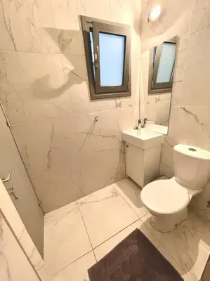 a white bathroom with a toilet and a sink at Demetra 1 Bdr Down Town Nicosia in Nicosia