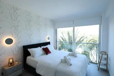 a bedroom with a white bed with a large window at Lovely cozy one bedroom suite with pool in Protaras