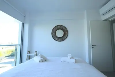 a bedroom with a white bed and a window at Lovely cozy one bedroom suite with pool in Protaras