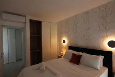 a bedroom with a bed with white sheets and red pillows at Lovely cozy one bedroom suite with pool in Protaras