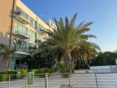 a palm tree in front of a building at Lovely cozy one bedroom suite with pool in Protaras
