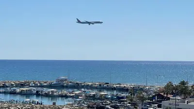 an airplane is flying over a marina with boats at Seascape 501 in Larnaka