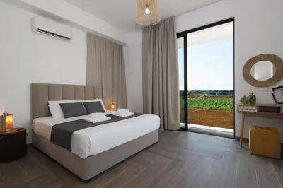 a bedroom with a large bed and a large window at Villa Queen Isabella in Protaras