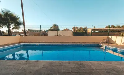 a blue swimming pool with the ocean in the background at The Chalk in Larnaka