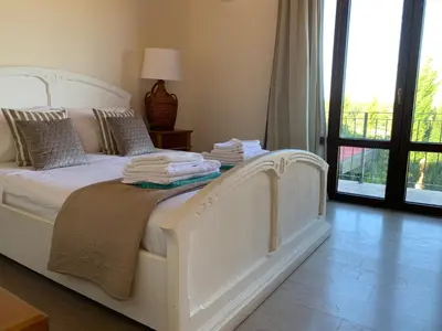 a bedroom with a white bed with towels on it at Villa Grand Zeus in Anoyira