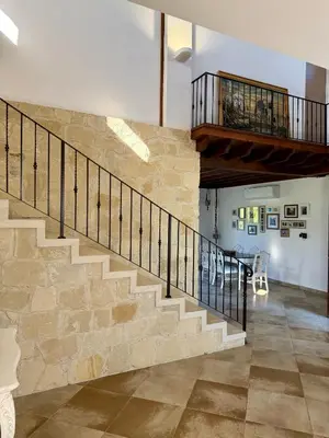 a staircase in a house with a stone wall at Villa Grand Zeus in Anoyira