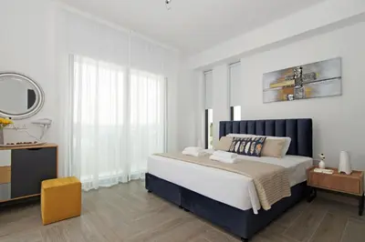 a white bedroom with a large bed and a mirror at Villa Queen Eleanor in Protaras