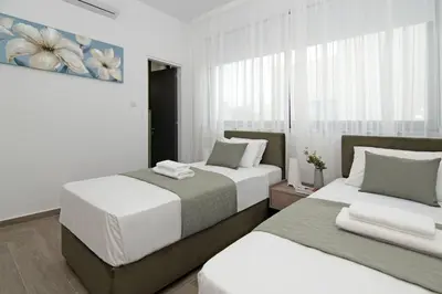 a bedroom with two beds and a painting on the wall at Villa Queen Eleanor in Protaras