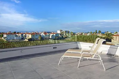 two white chairs sitting on top of a roof at Villa Queen Helena in Protaras