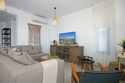 a living room with a couch and a tv at Villa Queen Helena in Protaras