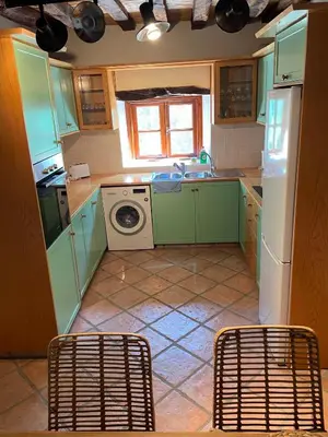 a kitchen with green cabinets and a washing machine at Stone built country house in Louvaras Village in Louvaras