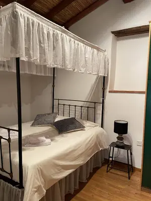 a bedroom with a canopy bed with a white curtain at Stone built country house in Louvaras Village in Louvaras
