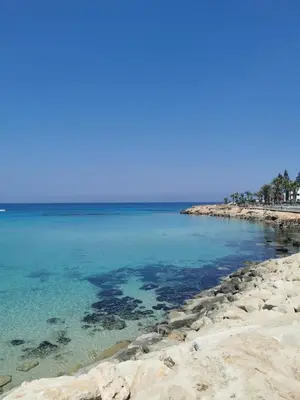 a beach with rocks and the blue water at Sea view cosy apartment in Protaras