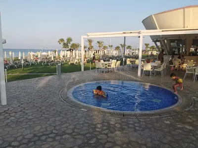 two children playing in a small pool at a resort at Sea view cosy apartment in Protaras