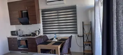 a kitchen with a dining table and a kitchen with a window at Oytam apt in Nicosia