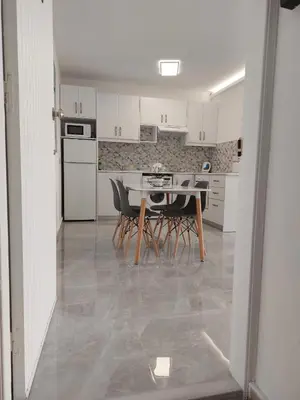 a kitchen with white cabinets and a table and chairs at Amazing Napa Apartment in Ayia Napa