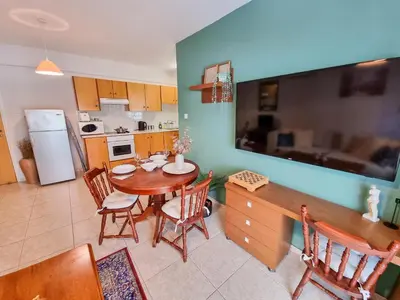 a kitchen and dining room with a table and chairs at Dock Holiday Apartment in Larnaka