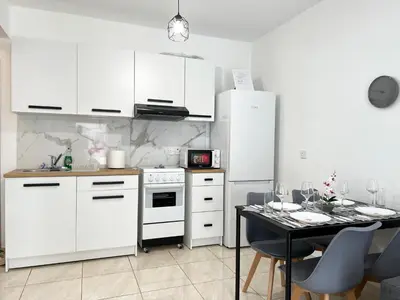 a kitchen with white appliances and a table with chairs at Albert's apartment Marina 15 in Larnaka