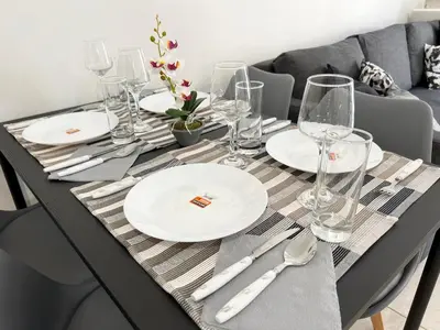 a black table with white plates and silverware on it at Albert's apartment Marina 15 in Larnaka