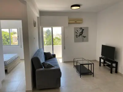 a living room with a couch and a television at 1-bedroom apartment with view in Limassol