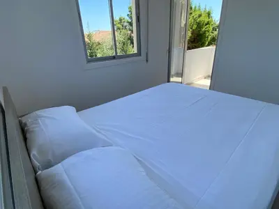 a white bed in a room with a window at 1-bedroom apartment with view in Limassol