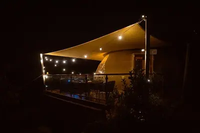 a house with lights on the side of it at night at Agros Glamping Boutique in Agros