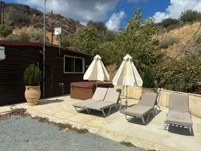 two chairs and two umbrellas on a patio at Sofros To Apomero in Ayios Pavlos