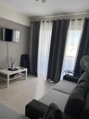 a living room with a couch and a table at Ptolemaidos cosy Family apartment in Larnaka