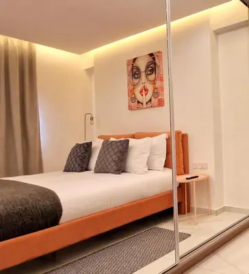 a bedroom with a bed with a mirror on it at Sveltos Residence Suites in Larnaka
