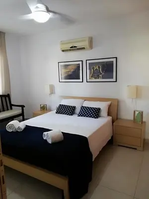 a bedroom with a large bed and a fan at Yiasemi Ground floor Holiday Appartment in Paralimni
