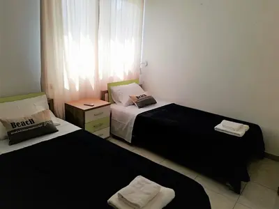 two beds in a small room with a window at Yiasemi Ground floor Holiday Appartment in Paralimni