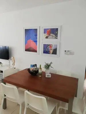 a dining room with a wooden table and white chairs at Yiasemi Ground floor Holiday Appartment in Paralimni