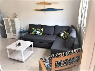 a living room with a blue couch and a table at Yiasemi Ground floor Holiday Appartment in Paralimni