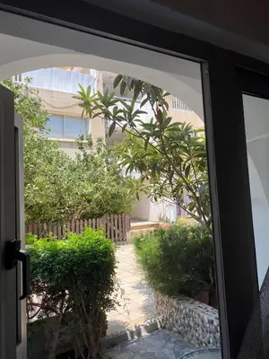a sliding glass door looking out at a garden at Stay With Oleg C17 in Paralimni