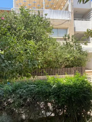 a fence with trees in front of a building at Stay With Oleg C17 in Paralimni